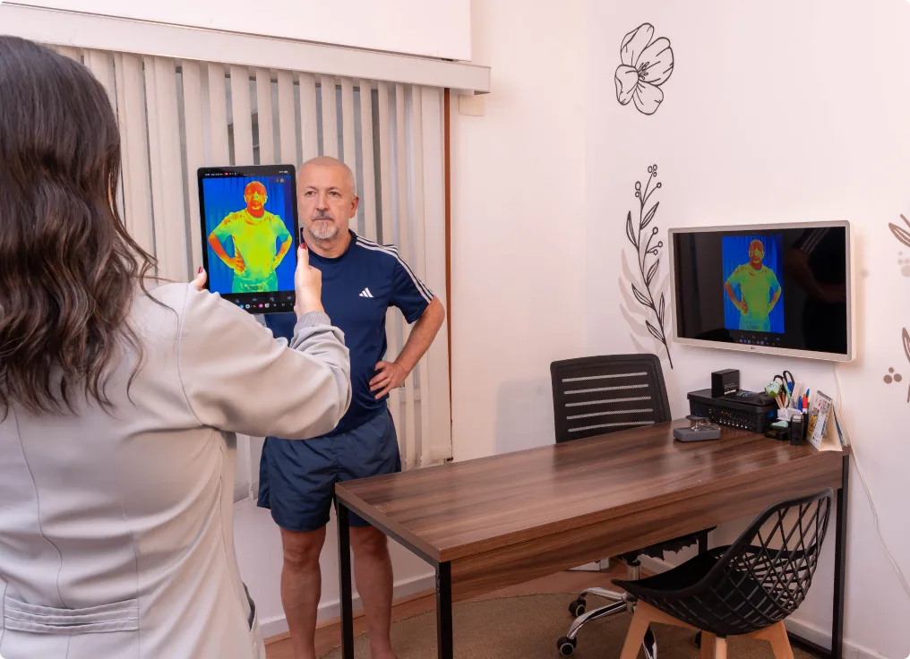 Fisioterapeuta registra imagem térmica de um paciente com um tablet.