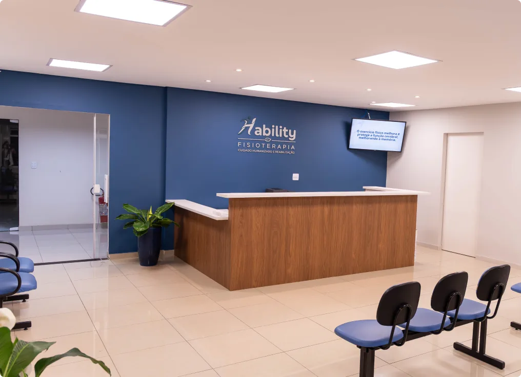 Recepção da clínica com balcão de atendimento e cadeiras para espera.